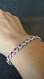 Luxury commercial display of SKU-AB122 3.30 carat ruby and diamond halo bracelet styled on a model wrist.