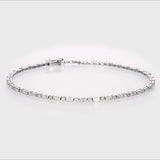 18KT white gold line bracelet showing precision bar-set baguette diamonds flanked by round brilliant diamonds with a visible 750 gold hallmark on the clasp.