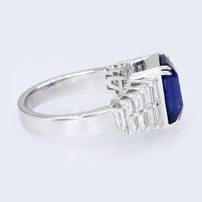 Close up video of natural blue sapphire in double claw setting with baguette diamond shoulders 18kt gold